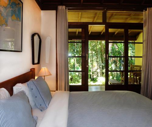 1 dormitorio con 1 cama y puerta corredera de cristal en Kanawha Hotel en Nova Friburgo