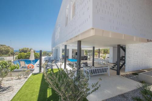 un gran edificio blanco con piscina y patio en Chloe Luxury Villas, en Protaras