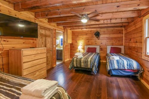 una camera con 2 letti in una baita di tronchi di SmokyStays Heated&Private Swim Spa cabin a Gatlinburg