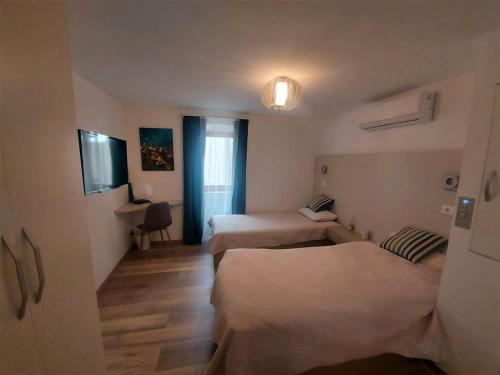 a hotel room with two beds and a window at NEW VILLA IN OLD CENTER - Pag in Pag