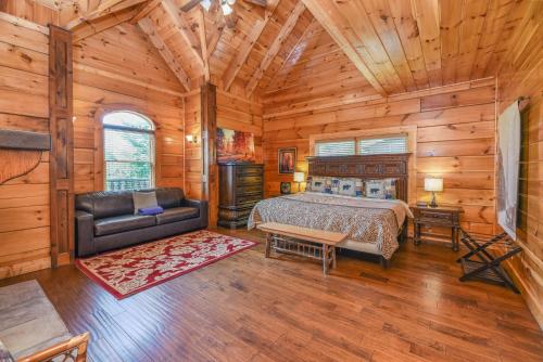 - une chambre dans une cabane en rondins avec un lit et un canapé dans l'établissement SmokyStays 6 Bedroom Cabin, à Pigeon Forge