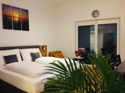 a bedroom with a bed and a potted plant at Sonnenweg Appartements in Rust