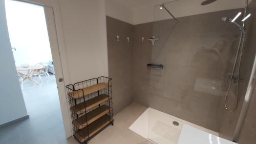 La salle de bains est pourvue d'une douche avec une porte en verre. dans l'établissement Villa HOME HOLIDAY à Cala Rossa, à Lecci