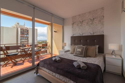 a bedroom with a large bed and a balcony at SUITE ON 7TH VILAMOURA THE BEST VIEW IN TOWN - 1Br in Quarteira