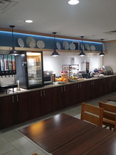 a kitchen with a wooden table and a counter top at Garner Hotel Gillette South by IHG in Gillette