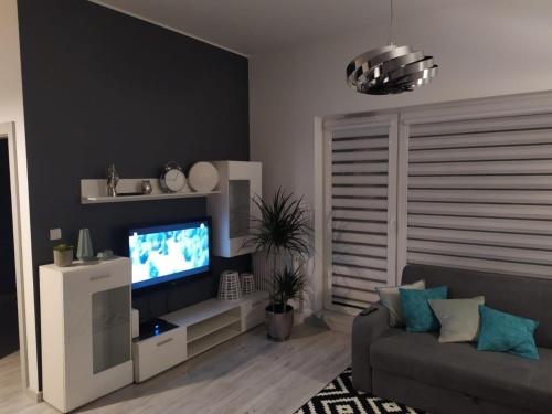 a living room with a television and a couch at Aqua Blue Apartament in Reda