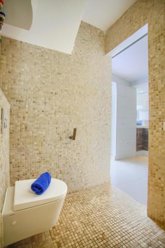a bathroom with a toilet with a blue towel on it at Neptuno Bungalows - Adults Only in Corralejo