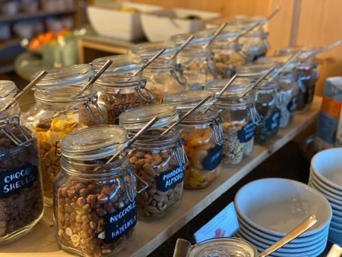 eine Reihe von Gläsern gefüllt mit Nüssen und Samen in der Unterkunft Dolasilla Mountain Panoramic Wellness Hotel in Stern