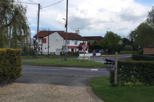 a street with a white building and a house at Foxes Den at Foxesway in Kirkby on Bain