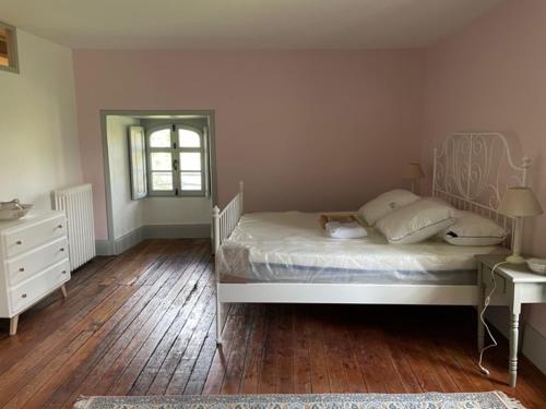 1 dormitorio con cama blanca y suelo de madera en Gîte proche Puy duFou en Mauléon