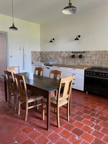 - une cuisine avec une table et des chaises en bois dans l'établissement Gîte proche Puy duFou, à Mauléon