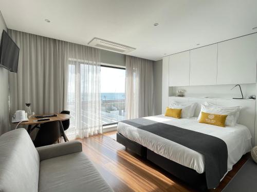 a bedroom with a large bed and a desk and a window at Praia de Santos, Exclusive Villa, Açores in Ponta Delgada