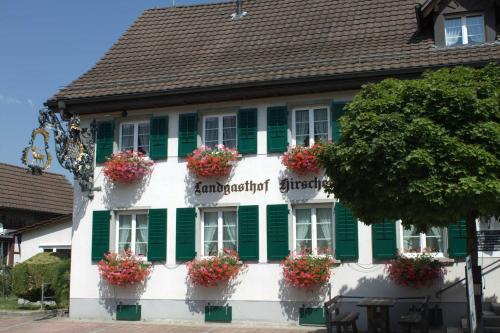 a building with green shutters and flower boxes on it at Hotel Landgasthof Hirschen in Ramsen