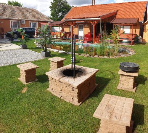 a backyard with a fire pit in the grass at Grevia Apartmanok in Poroszló