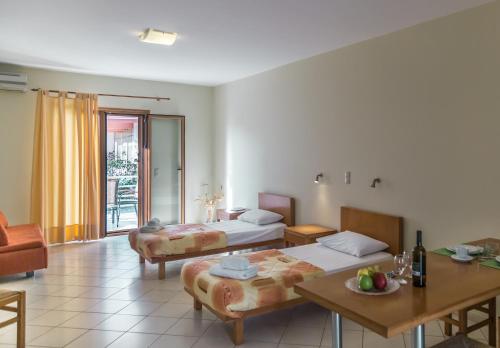 a hotel room with two beds and a table at Eleni Suites Methoni in Methoni