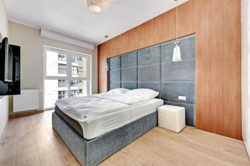 1 dormitorio con 1 cama grande y TV en Agapella Apartamenty - Apartament Albatros 15 floor en Gdansk