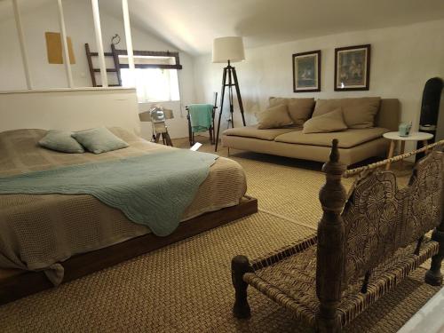 une chambre avec un lit et un canapé dans l'établissement Gites de charme en provence occitane, à Saint-André-dʼOlérargues
