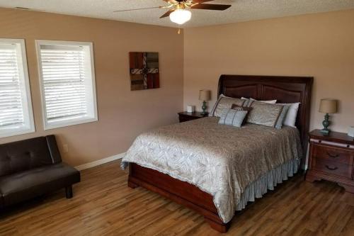 a bedroom with a bed and a couch and two windows at Lakehouse has Spectacular View plus Easy Access! in Rogers