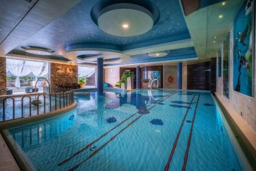 a large indoor pool in a hotel room with a large swimming pool at Hotel & SPA Czarny Groń in Rzyki