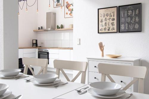 a kitchen with a table with bowls and chairs at Ferienwohnungen Galerie im Klink in Quedlinburg