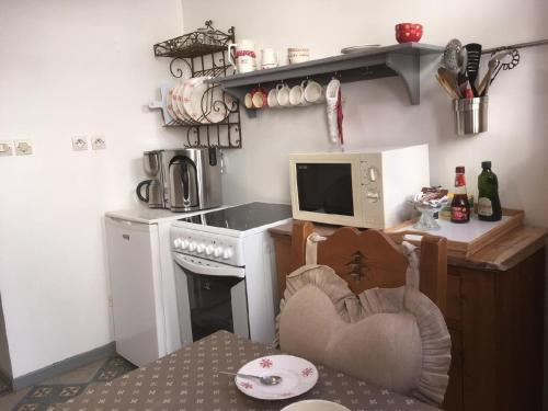 a small kitchen with a table and a microwave at Les mélèzes in Le Mont-Dore