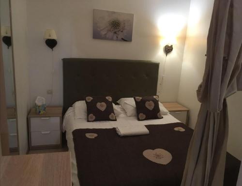 1 dormitorio con 1 cama con 2 almohadas en Les mélèzes, en Le Mont-Dore