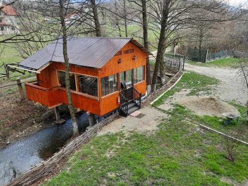 an orange tiny house on the tracks in a yard at Pensiunea Marina in Bran