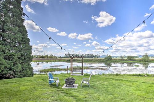 two chairs and a table in front of a lake at McMinnville Wine Country Home with Hot Tub and Deck in McMinnville