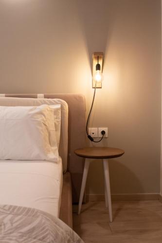 a bed and a table with a lamp next to a bed at Langi Apartments in Mesolongion