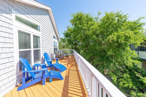 a deck with blue chairs on a house at Follow the Sun in Duck