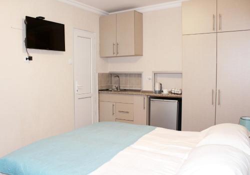 a white bedroom with a bed and a kitchen at Guest House Old Tiflis 5 in Tbilisi City