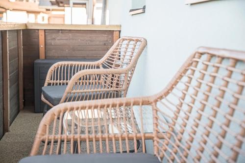 two wicker chairs sitting on a balcony at Mountain Base Fieberbrunn in Fieberbrunn
