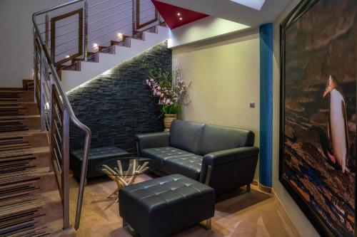 a living room with a couch and stairs at Hotel & SPA Czarny Groń in Rzyki