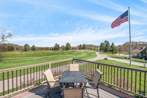 a table and chairs on a balcony with an american flag at Birchwood: Meadows Bliss in Harbor Springs
