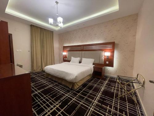 a hotel room with a large bed and a room at Shatha Abha Furnished Units in Abha