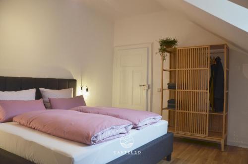 ein Schlafzimmer mit einem großen Bett mit rosa Bettwäsche in der Unterkunft Die Gründerzeitvilla zwischen Weinstrasse und Pfälzer Wald in Bad Bergzabern