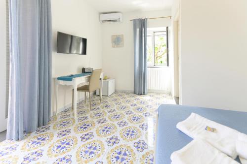 a bedroom with a bed and a desk and a table at B&B Mediterraneo in Procida