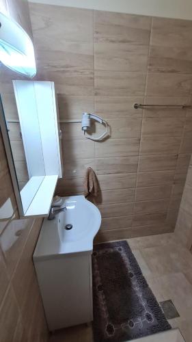 a bathroom with a white sink and a mirror at Annie's Apartment in Ialyssos