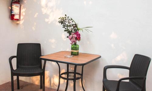 a table with chairs and a vase with flowers on it at Hacienda Cenote San Ignacio in Chocholá