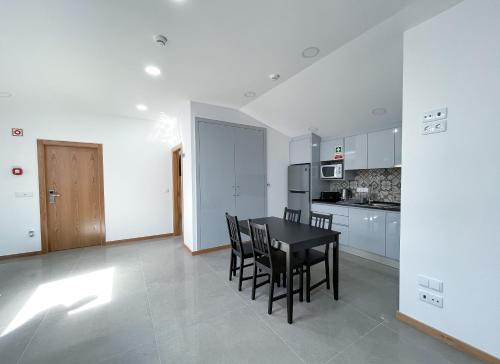 - une cuisine et une salle à manger avec une table et des chaises dans l'établissement Soldouro Train Suites, à Aveiro