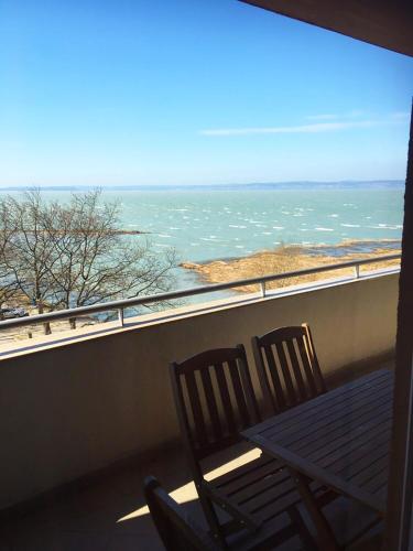 two chairs sitting on a balcony looking out at the ocean at Club 218 Wellness Luxus Apartman in Siófok