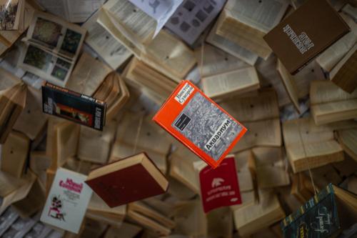 a pile of books sitting on top of a table at Tolstoy Art-Hostel in Kaliningrad