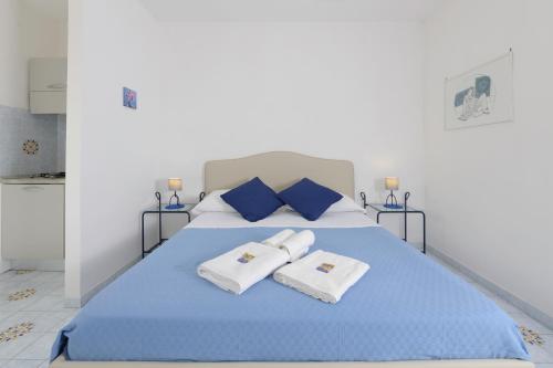 a bedroom with a blue bed with towels on it at B&B Mediterraneo in Procida
