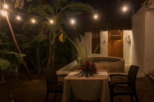 a table with chairs and a bath tub at night at Hacienda Cenote San Ignacio in Chocholá