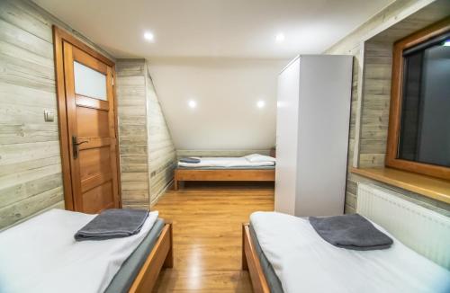 a small room with two beds and a window at Sielankowo-dom na wyłączność in Istebna