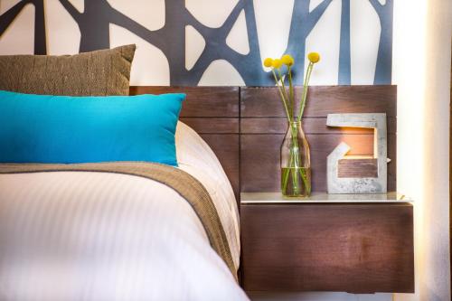 - une chambre avec un lit et un vase avec des fleurs dans l'établissement Areval Hotel Boutique de Lago & Eventos, à San Cristóbal Zapotitlán