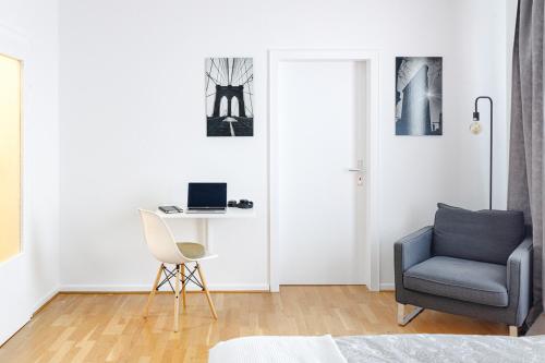 a living room with a chair and a desk with a laptop at Stylish apartment - 3 Min walk to Wuppertal main train station - Close to the University - Kitchen - Netflix in Wuppertal