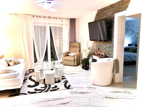 a living room with white furniture and a flat screen tv at Fabulous Lakeside Family Apartment | 4 Rooms in Montreux