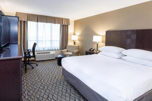 a hotel room with a large bed and a flat screen tv at Holiday Inn St. Louis Airport West Earth City by IHG in Earth City