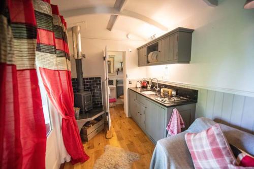 a small kitchen with a red curtain in a room at Thompson Hall Retreat in Thompson